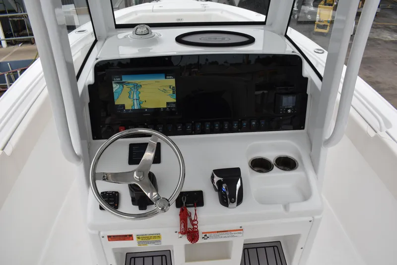 Slide: The Image of 2023 Sea Hunt Ultra 255 SE boat dashboard with steering wheel and navigation display. - 23