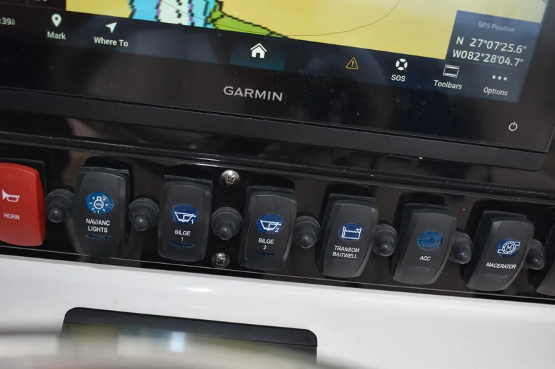 Slide: The Image of Control panel of 2023 Sea Hunt Ultra 255 SE with Garmin GPS display and switches. - 26