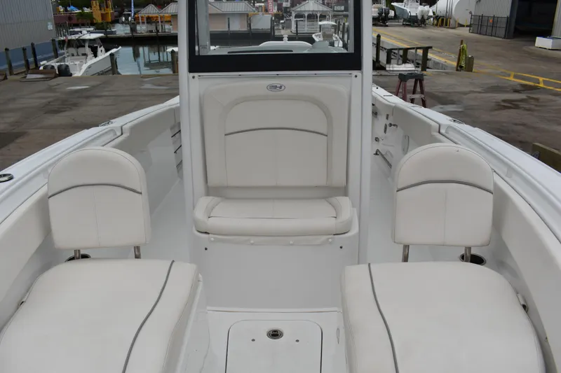 Slide: The Image of 2023 Sea Hunt Ultra 255 SE boat interior with white seating and dockside view. - 41