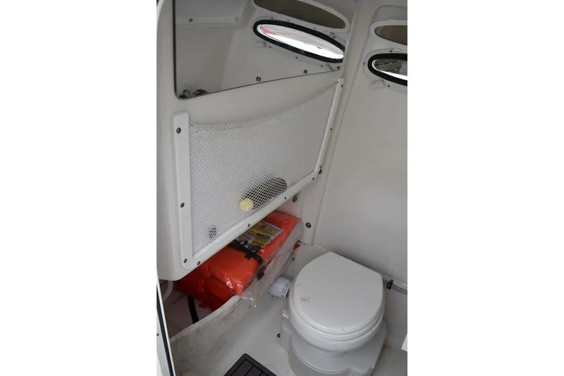 Slide: The Image of 2023 Sea Hunt Ultra 255 SE boat interior with toilet and storage compartment. - 46