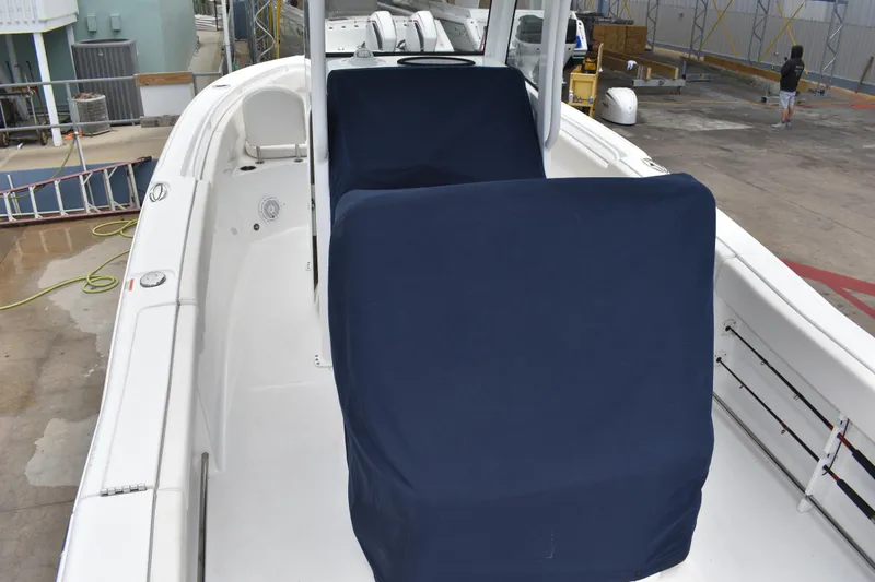 Slide: The Image of 2023 Sea Hunt Ultra 255 SE boat with covered seating, docked at a marina. - 48