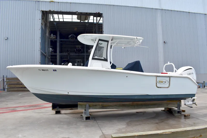 Slide: The Image of 2023 Sea Hunt Ultra 255 SE boat on display in a marina setting. - 5