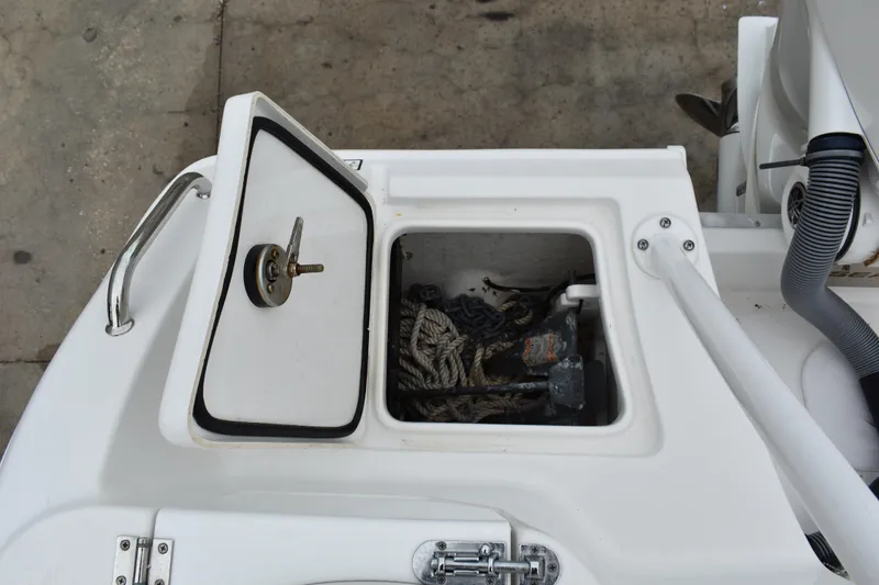 Slide: The Image of Open storage compartment on 2023 Sea Hunt Ultra 255 SE boat, containing ropes and equipment. - 9