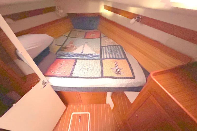 Slide: The Image of Cozy cabin interior of 2009 Catalina 375 sailboat with nautical-themed bedding. - 13