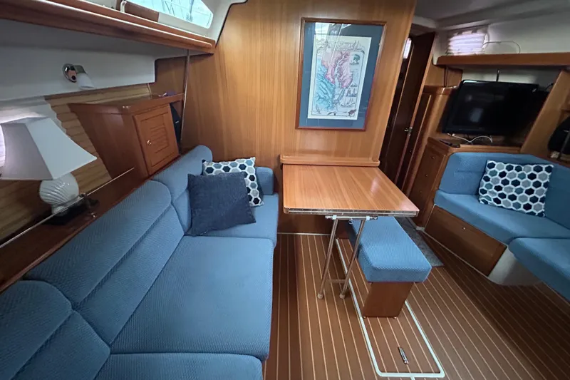 Slide: The Image of Interior of 2009 Catalina 375 sailboat with blue seating, wooden table, and nautical decor. - 19
