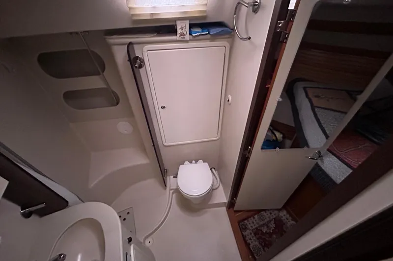 Slide: The Image of Bathroom interior of a 2009 Catalina 375 sailboat, featuring a compact toilet and sink. - 22