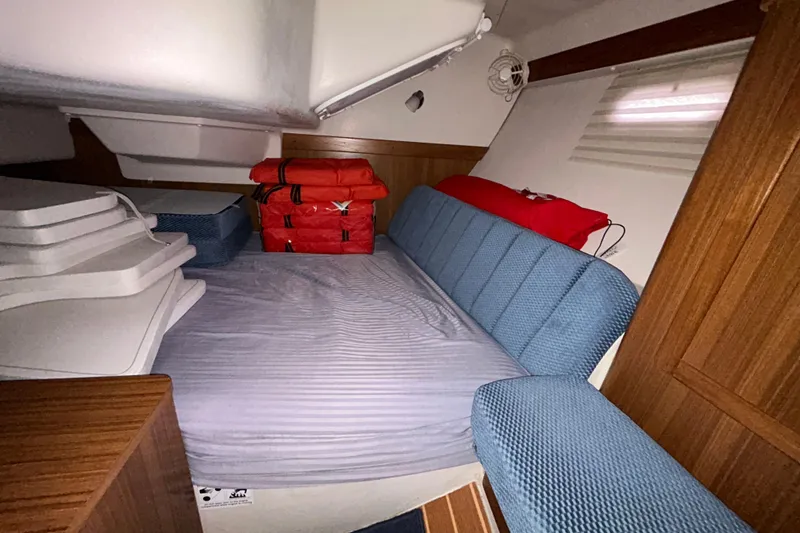 Slide: The Image of Cozy cabin interior of 2009 Catalina 375 sailboat with blue upholstery and safety gear. - 27