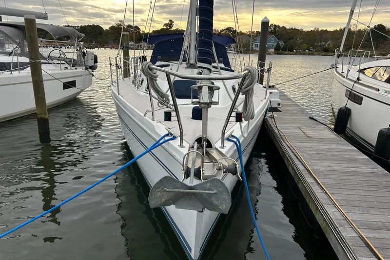 Slide: The Image of 2009 Catalina 375 sailboat docked at marina, front view, calm water, overcast sky. - 3