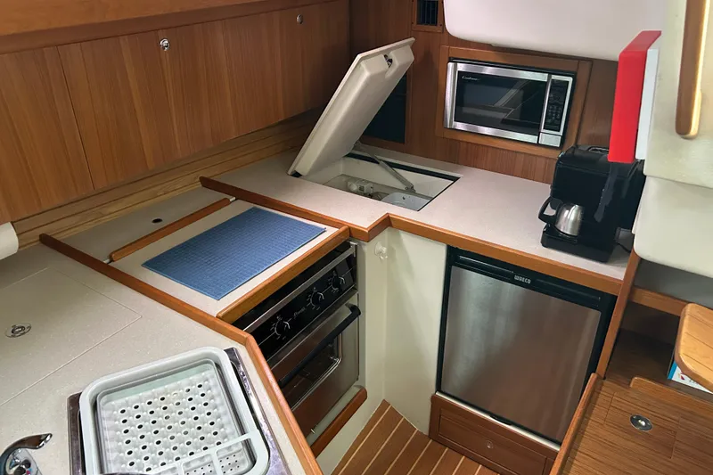 Slide: The Image of 2009 Catalina 375 yacht kitchen with stove, microwave, and compact fridge. - 9