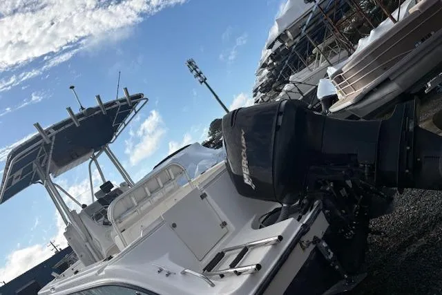 Slide: The Image of 2006 Trophy PRO 23 Center Console boat with outboard motor, docked under a clear sky. - 2