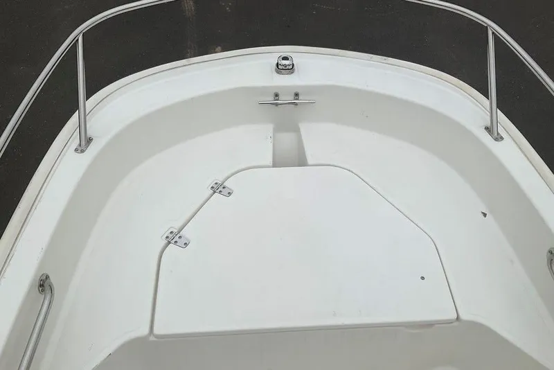 Slide: The Image of 2020 Boston Whaler 130 Super Sport boat interior with white deck and stainless steel railings. - 10