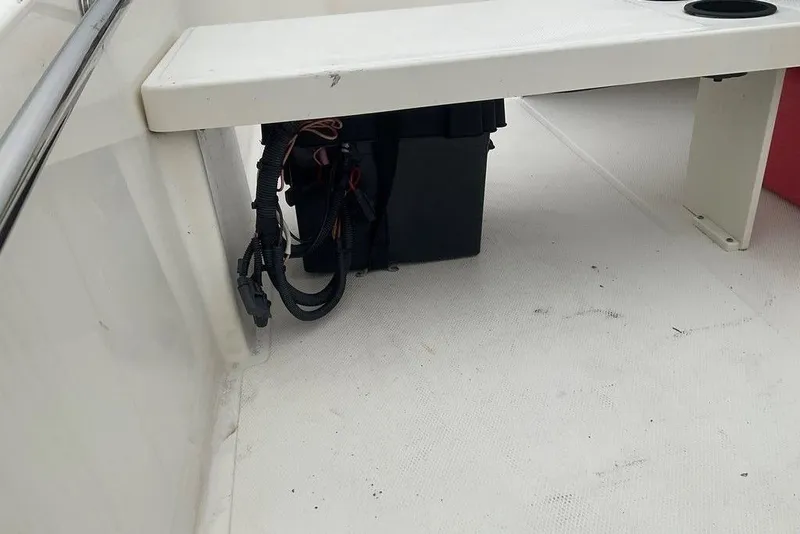 Slide: The Image of 2020 Boston Whaler 130 Super Sport interior with storage compartment and wiring. - 11