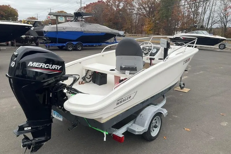 Slide: The Image of 2020 Boston Whaler 130 Super Sport boat with Mercury engine on trailer. - 12
