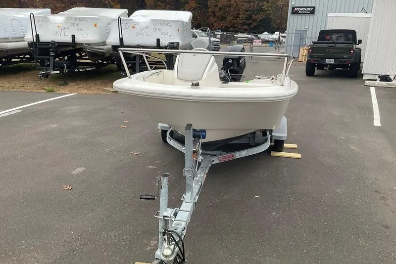 Slide: The Image of 2020 Boston Whaler 130 Super Sport boat on trailer in parking lot. - 2