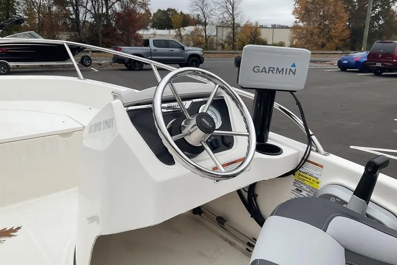 Slide: The Image of 2020 Boston Whaler 130 Super Sport boat with Garmin navigation system, parked outdoors. - 7
