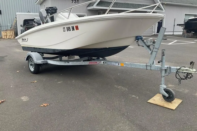 Slide: The Image of 2020 Boston Whaler 130 Super Sport boat on trailer in parking lot. - 8