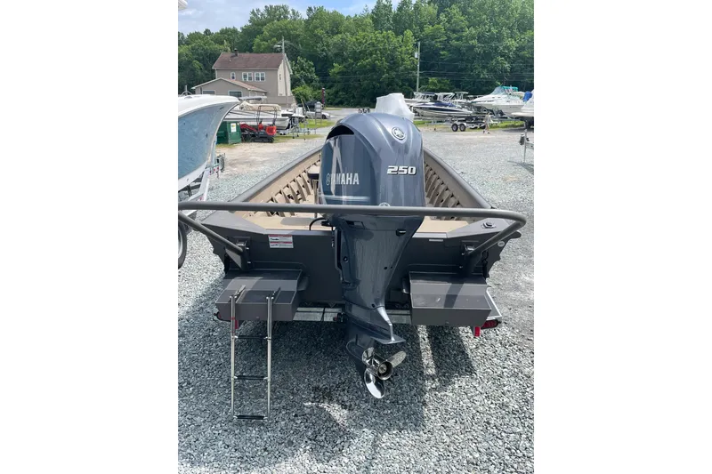 Slide: The Image of 2025 SeaArk 2672 CUB boat with Yamaha 250 engine, parked on gravel lot. - 3