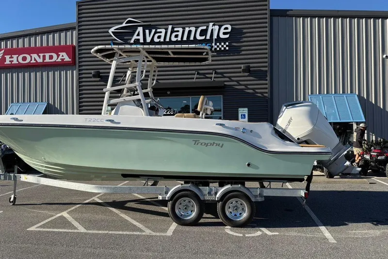 The Image of 2026 Bayliner Trophy T22CC boat on trailer outside dealership. - 1
