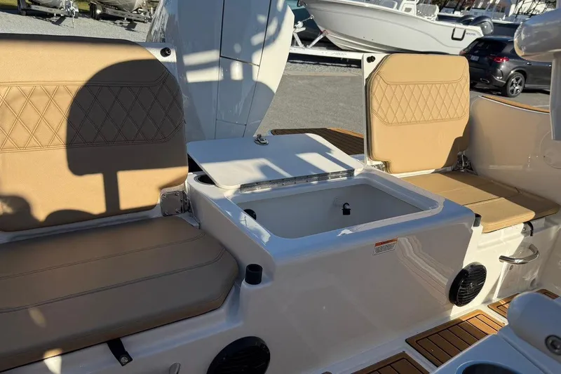 Slide: The Image of 2026 Bayliner Trophy T22CC boat interior with tan seating and storage compartment. - 16