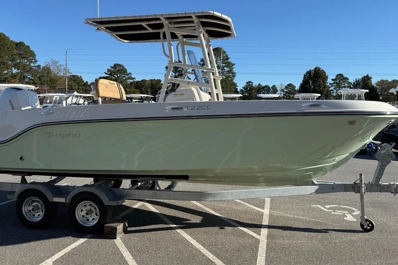 Slide: The Image of 2026 Bayliner Trophy T22CC boat on trailer in sunny outdoor setting. - 6
