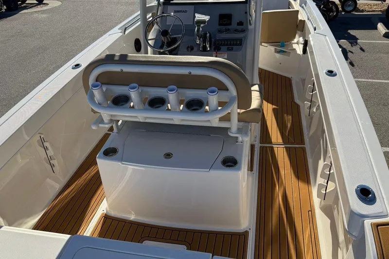Slide: The Image of 2026 Bayliner Trophy T22CC boat interior with rod holders and teak flooring. - 9