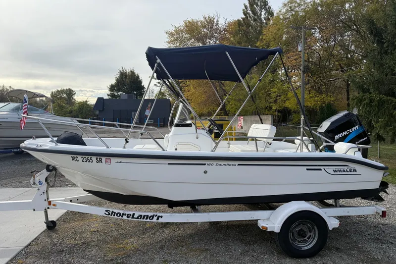 Slide: The Image of 2004 Boston Whaler 160 Dauntless boat on trailer with canopy and Mercury engine. - 3