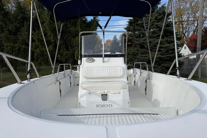 Slide: The Image of 2004 Boston Whaler 160 Dauntless boat with seating and canopy, parked outdoors. - 4