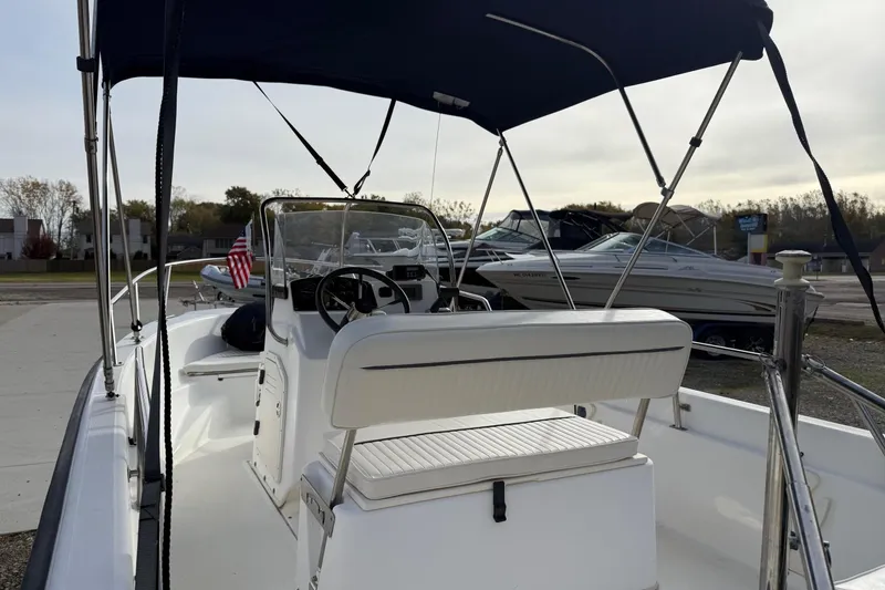 Slide: The Image of 2004 Boston Whaler 160 Dauntless boat interior with steering wheel and seating. - 6