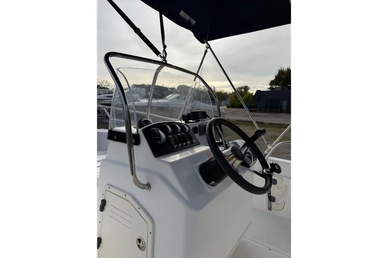 Slide: The Image of 2004 Boston Whaler 160 Dauntless boat console with steering wheel and controls. - 7