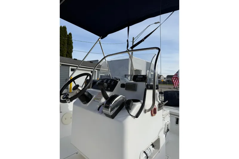 Slide: The Image of 2004 Boston Whaler 160 Dauntless boat console with steering wheel and controls. - 8