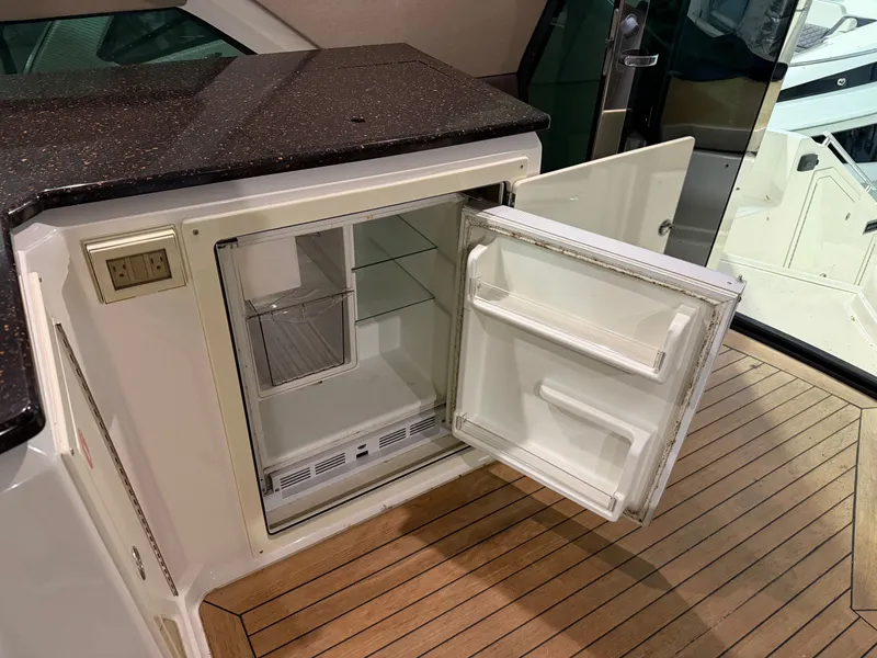 Slide: The Image of Open mini fridge on 2014 Regal 52 Sport Coupe yacht with wooden flooring. - 10