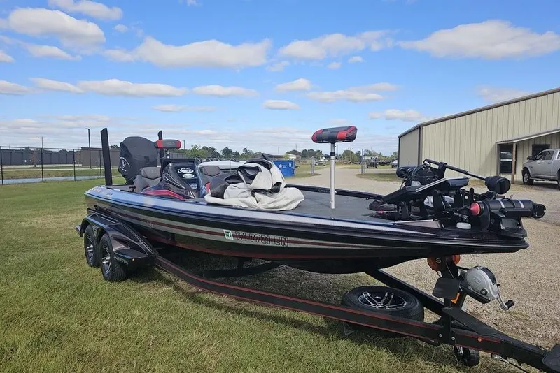 Slide: The Image of 2019 Skeeter FX21 bass boat on trailer, parked on grass under a blue sky. - 9