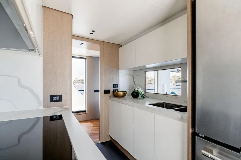 Slide: The Image of Modern kitchen interior on 2025 Azimut Grande 26M yacht, featuring sleek design and natural lighting. - 23