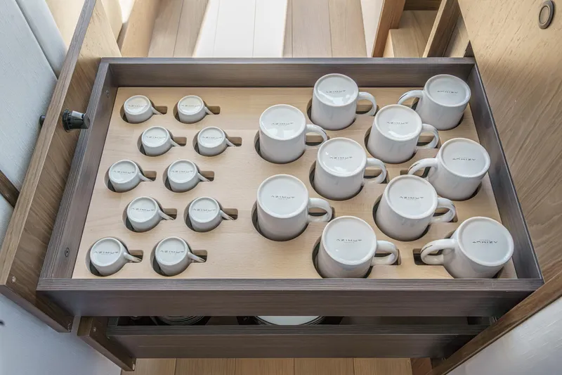 Slide: The Image of Drawer with neatly arranged Azimut-branded mugs on the 2026 Azimut Fly 72 yacht. - 53