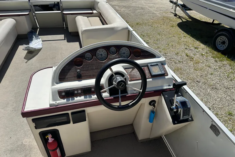 Slide: The Image of 1999 Crest 25 III Classic boat dashboard with steering wheel and control panel. - 8