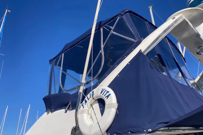 Slide: The Image of 1989 Bayliner 3288 Motoryacht deck with American flag, docked on calm water. - 12