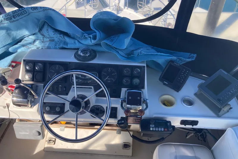 Slide: The Image of 1989 Bayliner 3288 Motoryacht with blue canopy and life preserver, under clear blue sky. - 13