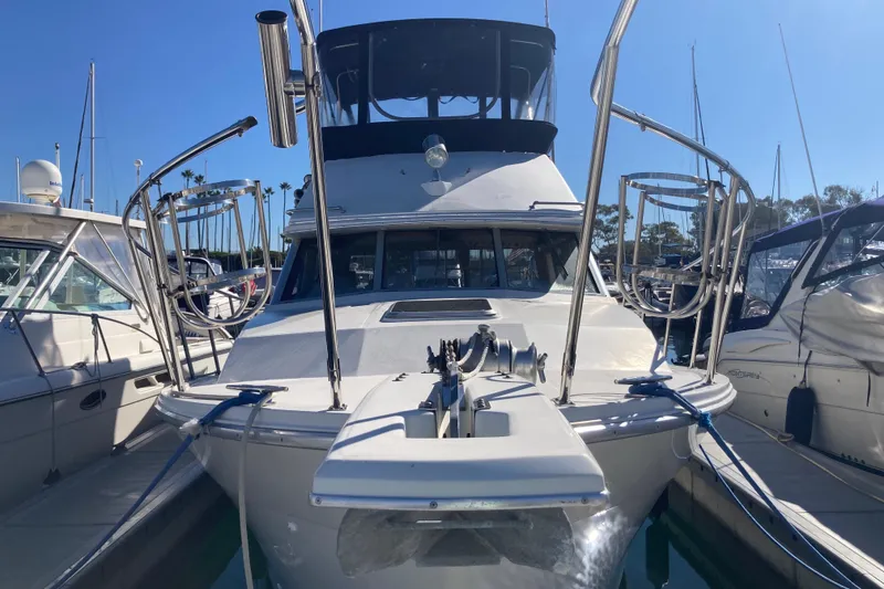 Slide: The Image of 1989 Bayliner 3288 Motoryacht docked at marina under clear blue sky. - 2