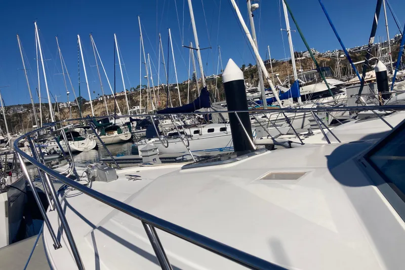 Slide: The Image of 1989 Bayliner 3288 Motoryacht docked at marina under cloudy sky. - 3
