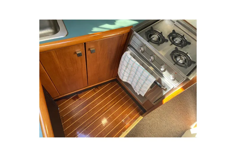 Slide: The Image of 1989 Bayliner 3288 Motoryacht kitchen with sink, countertop, and storage cabinets. - 30