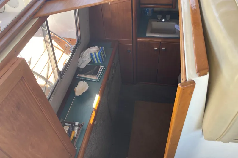 Slide: The Image of 1989 Bayliner 3288 Motoryacht interior with table, framed photo, plant, and speaker. - 38