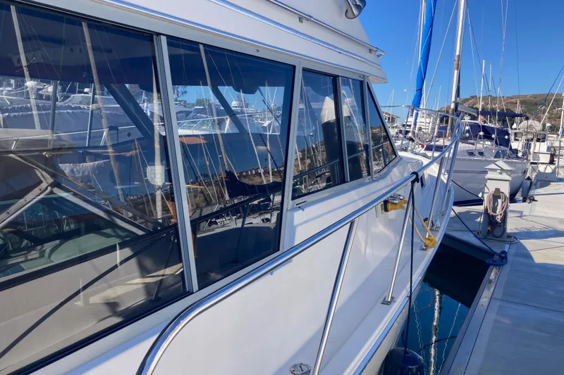 Slide: The Image of 1989 Bayliner 3288 Motoryacht docked at marina, side view with windows and railing. - 5