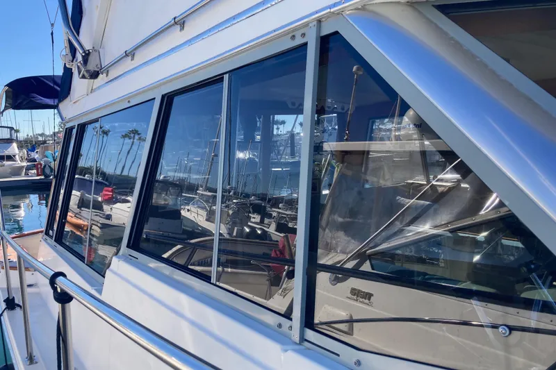 Slide: The Image of 1989 Bayliner 3288 Motoryacht docked at marina, reflecting clear blue sky. - 6