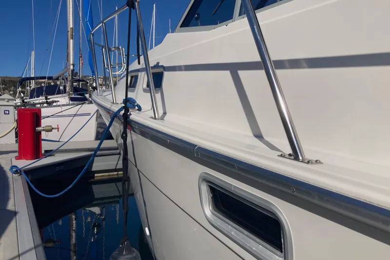 Slide: The Image of 1989 Bayliner 3288 Motoryacht docked, reflecting marina and palm trees in windows. - 7