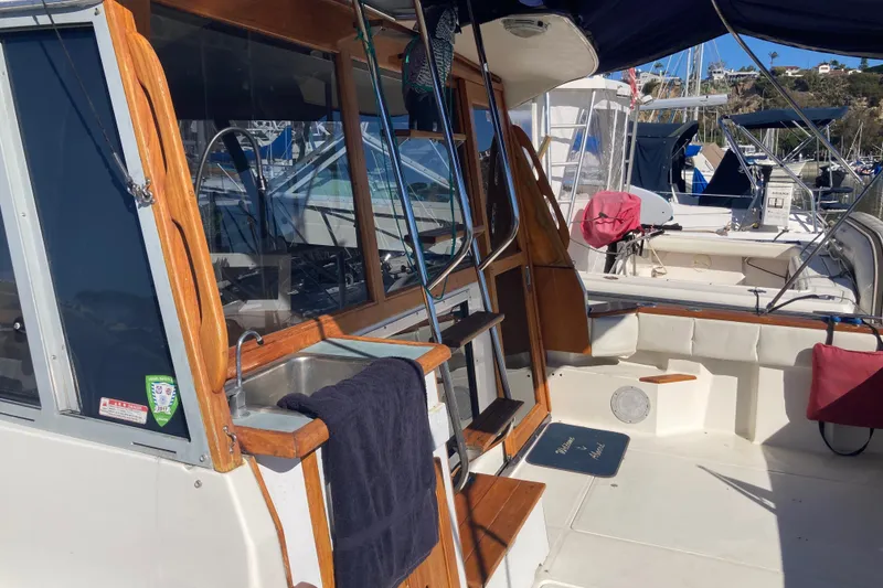 Slide: The Image of 1989 Bayliner 3288 Motoryacht docked at marina, side view with railing. - 8