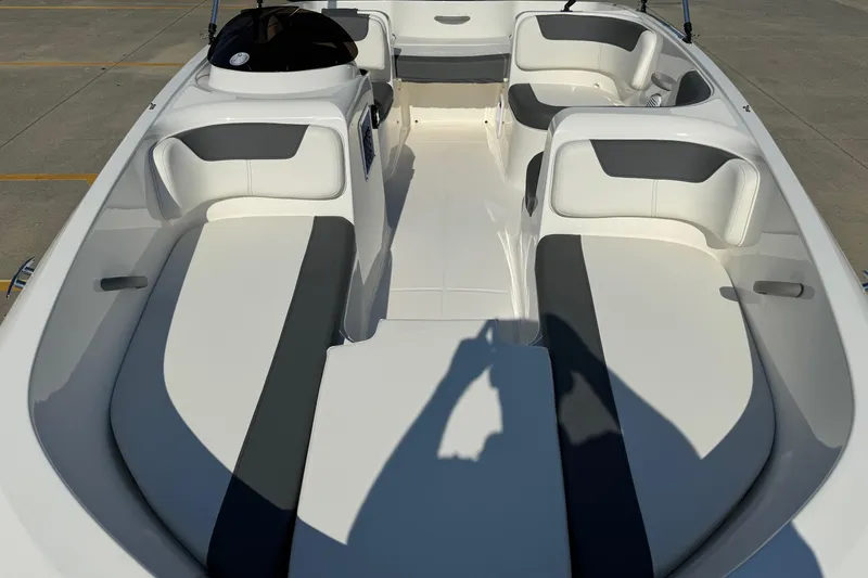 Slide: The Image of 2025 Bayliner Element E16 boat interior with white and gray seating, docked on concrete. - 18