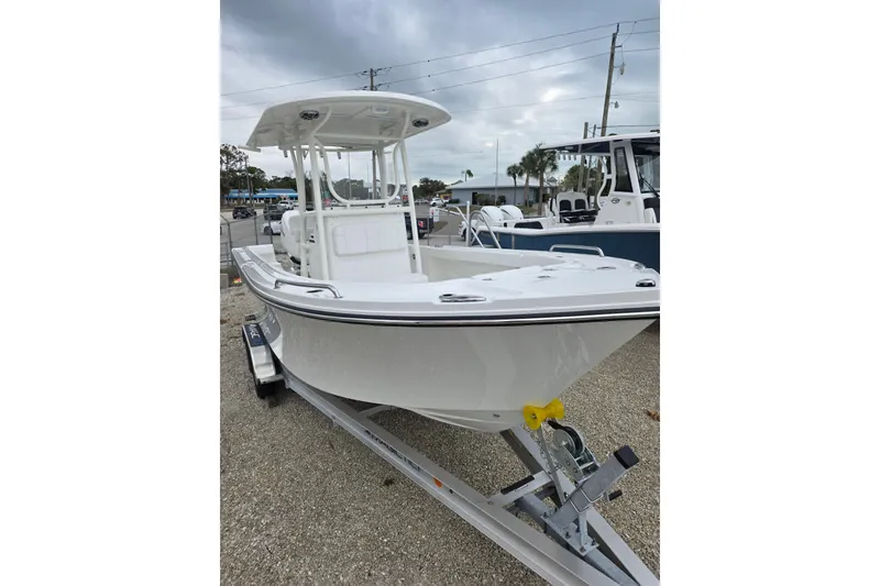 Slide: The Image of 2026 Parker 230 Coastal Elite boat on trailer, displayed outdoors under cloudy sky. - 14