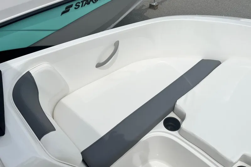 Slide: The Image of 2026 Bayliner Element E16 boat interior with white and gray seating, cup holder visible. - 9
