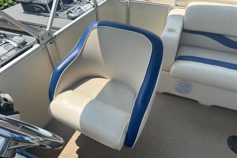 Slide: The Image of Captain's chair on a 2004 Crest 20 II LM boat, featuring blue and white upholstery. - 11