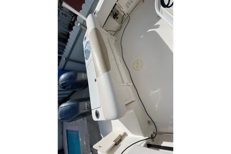 Slide: The Image of 2018 Robalo R242 Center Console boat interior with dual engines, white deck, and storage compartments. - 24